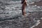 A child on the beach.Children`s feet on the background of the contrasting sun are immersed in the sand, which is washed by a wav