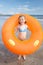 Child on beach with giant rubber ring