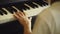 Child beginner piano player hand playing on piano key slow motion, closed up shot.