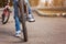 Child on a bicycle at asphalt road in sunny spring day. Closeup on pedal and foot