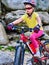 Child on bicycle ride mountain. Girl traveling in summer park.