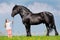 Child and big horse in field