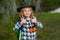 Child with binoculars travelling outdoors. Boy traveler with backpack in a summer day. Portrait of a little boy