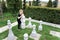 Child in black clothes is playing with huge chess pieces on the lawn has taken a chess piece in the hands of a knight and is