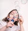 Child blowing bubbles with bubble wand