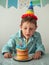 Child blows out the candle on birthday donuts cake