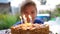 The child blows out the candles on the cake on his birthday. Children`s holiday