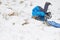 A child in a blue jacket rides in the snow. Baby rolled upside down rolling down the slide. snow winter