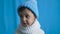 Child in a blue knitted hat and white sweater
