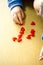 Child boy align the lot red hearts motifs on wooden background