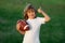 Child boy with american football, rugby ball. Kid boy playing with rugby ball in park. Cute portrait of a american