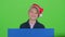 Child boy appeared from behind a blue poster to look at him shakes her head. Green screen