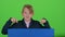 Child boy appeared from behind a blue poster to look at him shows like hiding again. Green screen