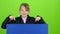 Child boy appeared from behind a blue poster to look at him shows like hiding again. Green screen. Slow motion