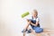 Child boy Builder holds construction tools in an apartment with white walls, child paints the walls, place for text, repair