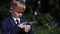 Child boy in business suit use smart watch on the street. Close up shot