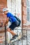 Child boy climbing over metal fence in a street,