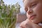 Child boy close up looking at snowdrops