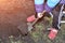 Child boy in a colored jacket digs a shovel in the garden