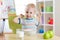 Child boy eating healthy food and showing his strength indoors