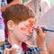 Child boy face painting, making tiger eyes process