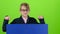 Child boy in the glasses gets up and shows on a board on a green screen. Slow motion