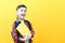Child boy in glasses isolated on yellow paper wall. Great idea. Happy smiling schoolboy goes back to school