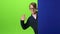 Child boy in glasses peeps out from the blue wall on a green screen. Slow motion