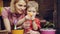 Child boy helps mother to care for plants flowers. Mom and son gardening at home. Happy family.