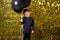 child boy holding black balloons on background with gold shiny sequins, paillettes.