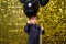 child boy holding black balloons on background with gold shiny sequins, paillettes.