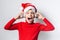 Child boy holds listening to Christmas music with funny Santa Claus hat on white background