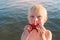 Child boy holds starfish against sea. Rest with children on beach