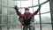 Child boy with instructor is flying in aerodynamic tube and looking at camera.