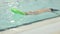 child boy kid swimming alone in pool holding green floating board learning swim