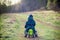 child boy in nature, riding a small balance bike