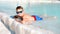 Child boy in outdoor nature pool in the background. Happy boy in sunglasses relax in blue water. Family vacation in