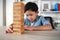 Child Boy Playing Jenga Game Exciting on Desk at Home. Unleashing Fun and Skill. Careful and Attentive Keeping, Concentrate and