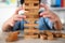 Child Boy Playing Jenga Game Exciting on Desk at Home. Unleashing Fun and Skill. Careful and Attentive Keeping, Concentrate and