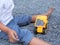 Child boy playing yellow car truck toy outdoor with dirty foot