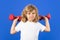 Child boy pumping up biceps muscles with dumbbell. Fitness kids with dumbbells.