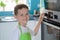 Child boy regulating temperature of the oven.