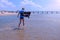 Child boy on sea vacation walks at sea water rest on sandy beach in windy day.