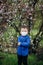 Child boy stands with a medical protective respirator on his fac