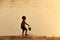 Child boy on sunset beach silhouette.