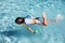 Child boy swimming face down in blue water pool