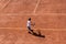 Child boy tennis player ready for service on a red - orange clay court. Top view, copy space. Kids tournament, match