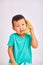 A child boy in a turquoise shirt, holds a banana in place of a phone while talking about a conversation - fruits and a healthy die