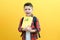 Child boy, on a yellow wall background. Great idea. Happy smiling schoolboy goes back to school. Success, motivation, winner,