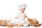 Child with bread on bakery-like background wearing cook-hat